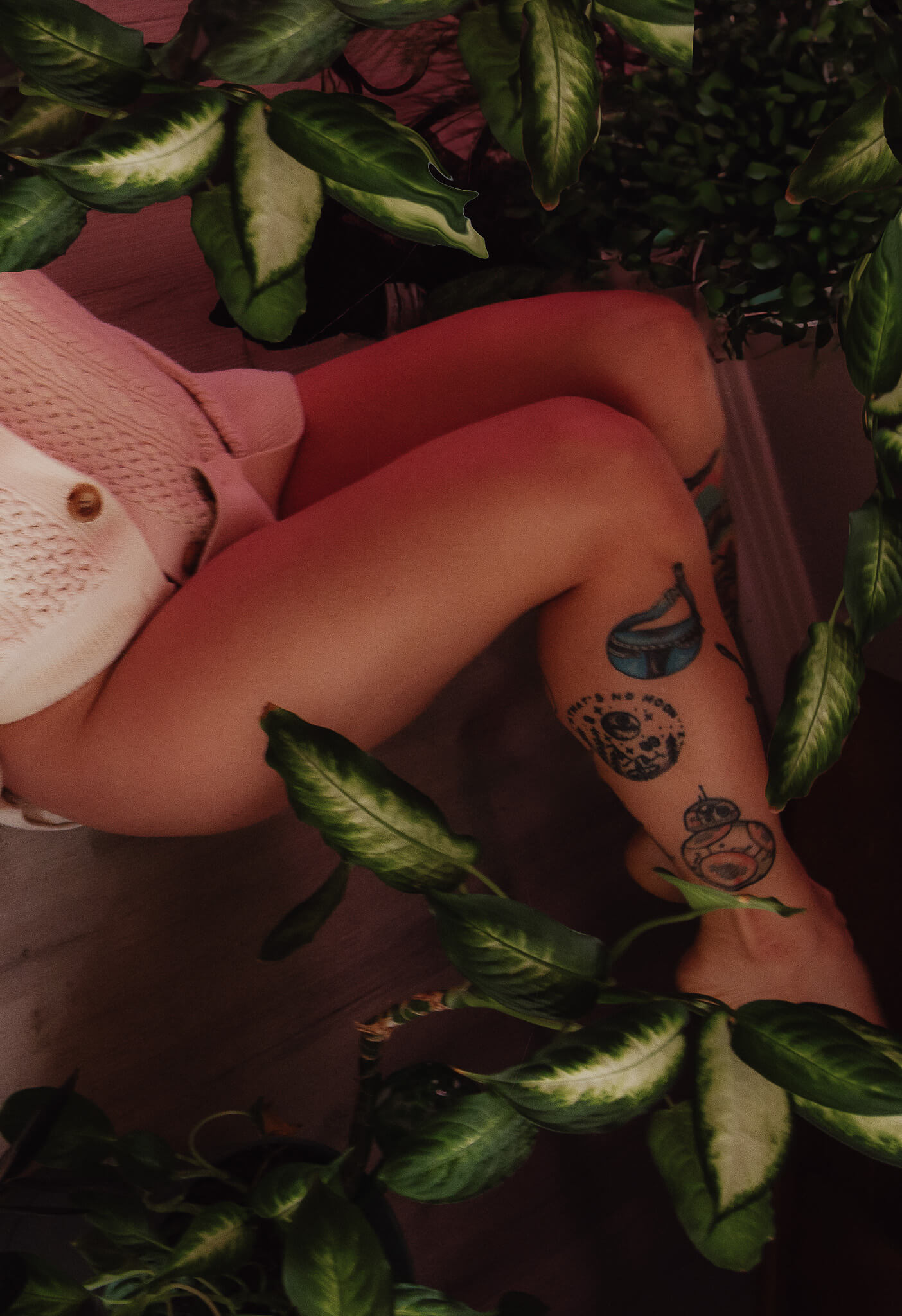 Intimate image of a woman's bare legs with plants for a boudoir shoot